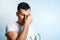 Close-up portrait of a man, covering his face with his hands. On a light background. The concept of body language