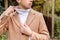 Close up portrait of man dressed in many layers of clothing - beige wool coat, cardigan and white high neck turtleneck - thermal