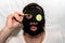 Close up portrait of mature man with facial moisturizing mask puts cucumber slices