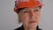 Close up portrait of a mature woman builder in a helmet. The profession is a civil engineer or an architect. Serious