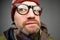 Close up portrait of middle aged europeam man in funny warm hat and glasses noticing hidden camera.