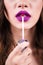 Close up portrait model applying purple lipstick.. Professional fashion make up.