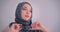 Close-up portrait of muslim businesswoman in hijab plays with her eyeglasses being immersed in thoughts.