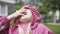 Close-up portrait of nice positive little girl in pink hood looking up and talking. Joyful beautiful Caucasian child