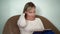 Close-up portrait of a nice woman with short blond hair, who is in a cozy office, sitting on a chair and thoughtfully