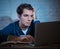 Close up portrait of a overworked and tired young man studying late at night on moody light