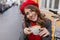 Close-up portrait of pale brunette girl with charming smile gently holding cup of coffee. Outdoor photo of fascinating