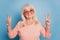 Close up portrait of pensioner lady showing two v-signs