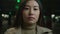 Close up portrait pensive serious Asian chinese ethnic woman young girl businesswoman female in dark parking city
