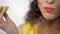 Close up portrait plump lips with bright orange lipstick biting sour piece of lemon with pleasure. Slow motion