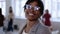 Close-up portrait, positive beautiful young African office employee woman in eyeglasses smiling at modern loft office.