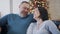 Close-up portrait of positive Caucasian man and woman talking and laughing with New Year tree at the background. Relaxed