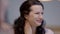 Close-up portrait of positive charming Caucasian woman smiling sitting in cafe or restaurant with friends or relatives