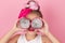 Close-up portrait of pretty girl with pink hairstyle with dragon fruit on pink background. Studio shot of charming tween