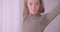 Close-up portrait of pretty professional ballerina dancing near window being calm and concentrated in light studio.