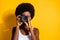 Close-up portrait of pretty wavy-haired brunette girl using digicam taking pictures snap isolated over bright yellow