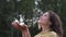 Close up portrait of pretty woman looking up at rain in nature. Young woman rejoices in the summer rain. Woman raises