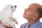 close up portrait in profile of man looking to maltese dog,isolated