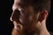 Close up of portrait of profile of a pensive man on black background