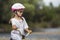 Close-up portrait of proud pretty young girl in white clothing, sunglasses with long blond braids wearing pink safety helmet ridin