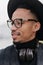 Close-up portrait of refined young man with brown skin. Photo of dreamy african male model in glasses and headphones