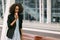 Close-up portrait of the sad afro-american woman talking on the mobile phone in the street.