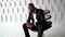 Close-up portrait of a sad and bearded middle-aged African-American man, looking at the phone and posing sitting on an