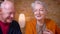 Close-up portrait of senior gray-haired caucasian spouses talking with each other being glad and happy.