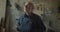 Close-up portrait of senior male carpentry master standing at wood manufacture watching into camera being serious and