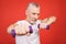 Close-up portrait Of A Senior Man Exercising with dumbbells against red Background