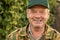 Close up portrait of a senior man wearing a cap and a camouflage jacket