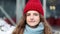 CLose up portrait serious curly haired young woman with red hat look at camera at city center. Fshion girl stand on