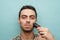 Close up portrait of a serious shirtless man shaving