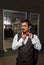 Close-up portrait of a sexy young elegant man holding a jacket on his finger behind his back and straightening a red bow tie,