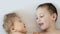 Close-up portrait of siblings lying on bed. Boy loves his disabled younger brother. - image