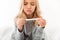 Close-up portrait of sick unhappy little girl holding thermometer