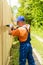 Close up portrait of skilled handyman mounting wooden board fence