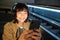 Close up portrait of smiling asian girl student, listens music in headphones and looks at mobile phone, uses smartphone