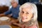 Close-up portrait of smiling caucasian senior woman holding biracial man\\\'s hand at dining table