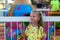 Close-up portrait of smiling girl near the carousel at the fair. Portrait of a cute girl on the background of an amusement park