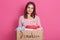 Close up portrait of smiling girl volunteering holding paper box with clothes for poor people, lady making donation, female wears