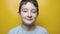 A close up portrait of a smiling pretty adorable boy against yellow background