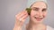 Close-up portrait of a smiling woman with braces doing home care with a gouache massager.