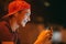 Close-up portrait of a smiling young man with a smartphone, in street at night.  Happy teenage boy is using mobile phone, outdoors