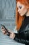 Close up portrait of stylish redhead young woman using tablet