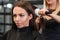 Close-up portrait of stylist drying woman hair in salon