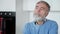 Close-up portrait of thoughtful bearded grey-haired Caucasian man sitting at home thinking. Handsome senior troubled guy