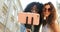 The close-up portrait of two charming smiling girls sending air kisses while making selfie. One of them is afro-american