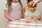 Close up portrait of two funny cute little girl looking on woman hand pouring fresh honey from jar into bowl.