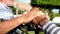 Close up and portrait of two hands shaking together and old and mature people talking sitting on a bench and having fun - taking c